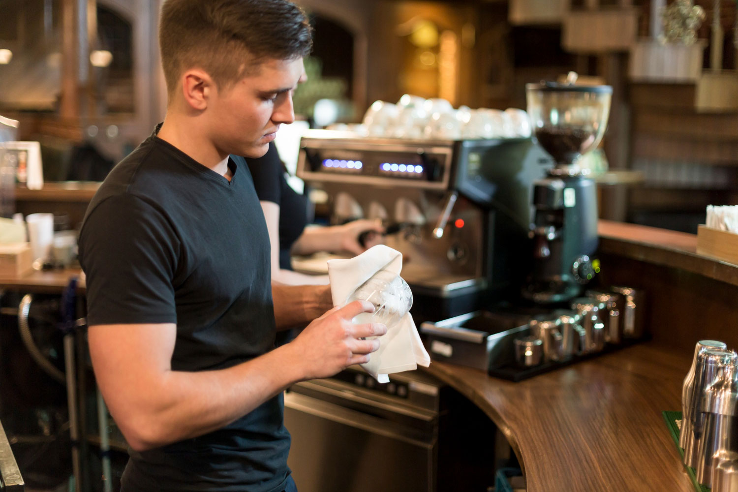 Barista lavora dietro al banco durante il servizio in un bar